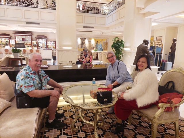 Three people seated in an elegant hotel lobby.