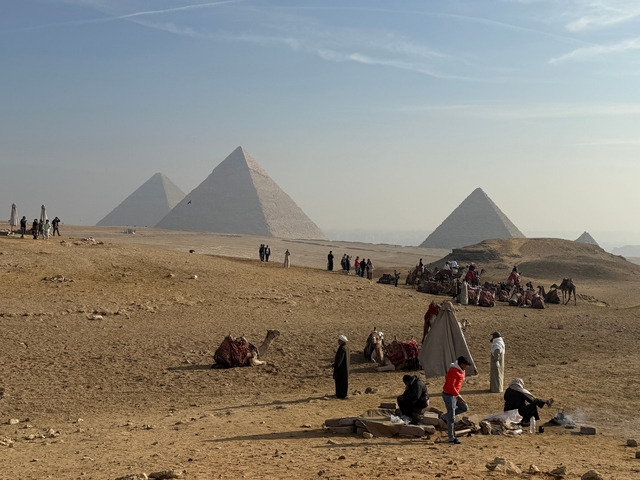 People and camels near the Pyramids in Giza.