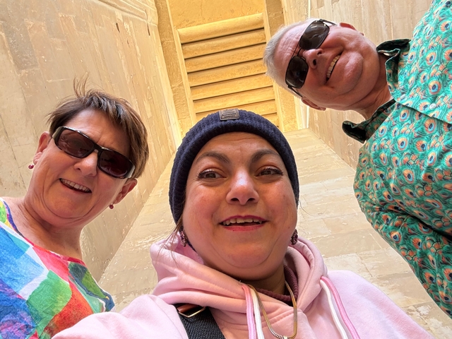 Three people taking a selfie outside a large stone structure.