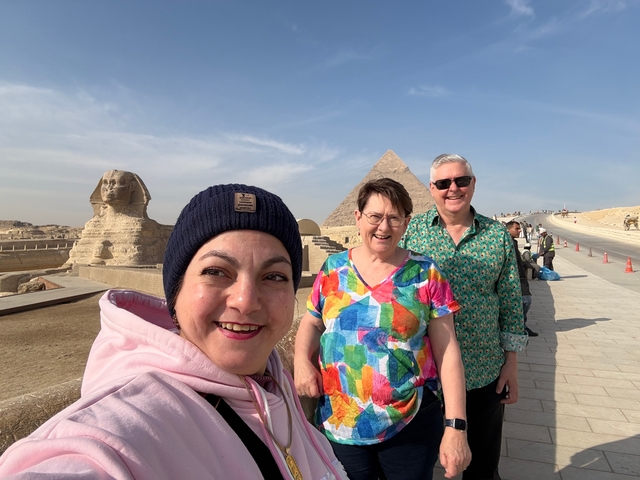 Three people posing near the Sphinx and Pyramid in Giza.