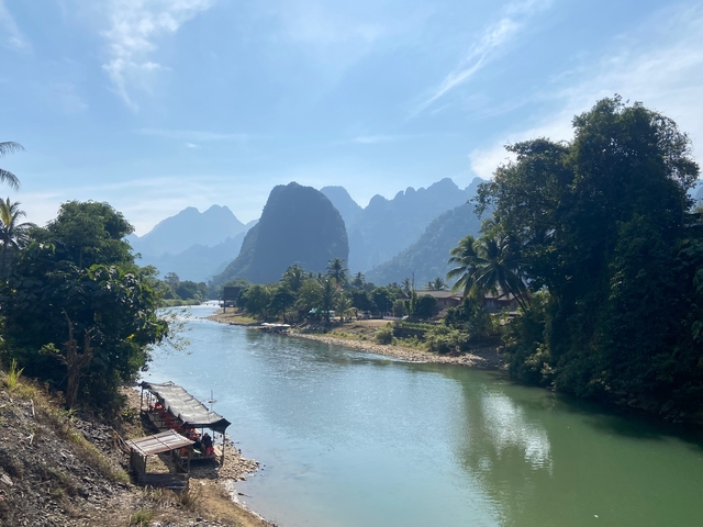 Scenic river with mountains and trees on either side.