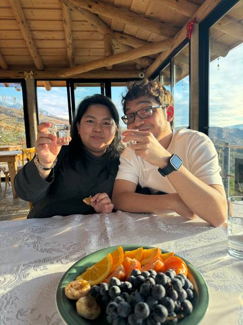 Two people holding glasses inside a restaurant.