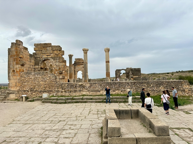 Tourists exploring ancient Roman ruins.