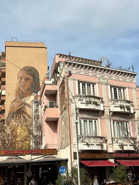 Street view of a building with a large mural painted on it.