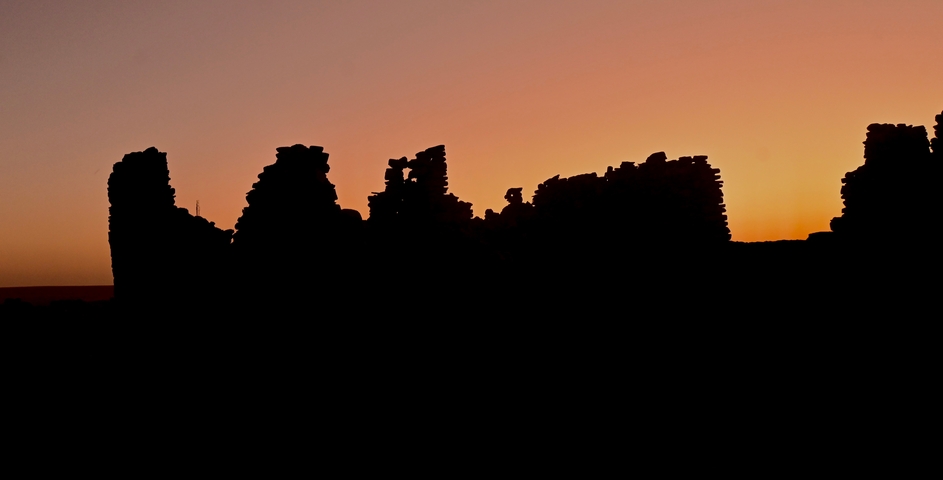 Silhouette of ruins against a sunset sky