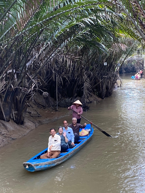 Group on a boat paddling through a dense waterway.