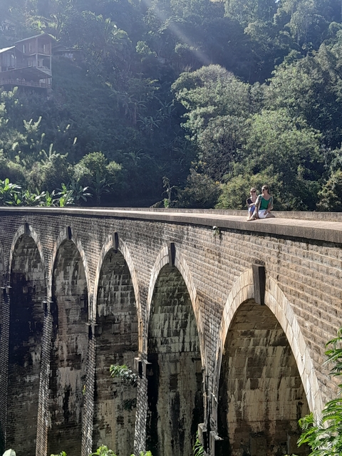 Two people sitting on a famous train bridge.
