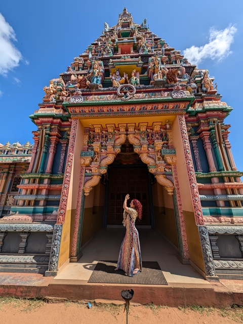 Person photographing a colorful temple entrance.