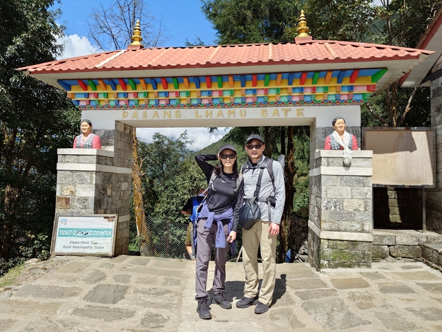 Two hikers standing in front of Pasang Lhamu Gate.