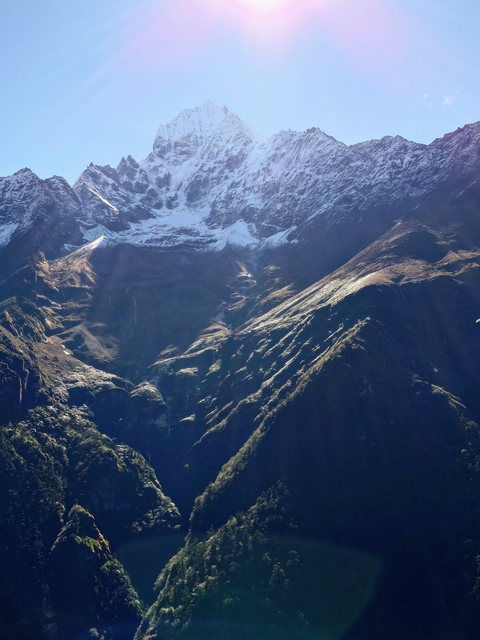 Mountain peaks with sunlight and shadows creating a dramatic effect.