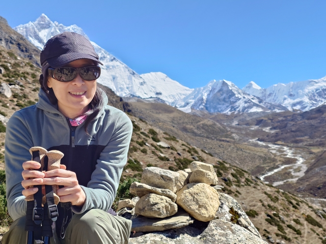 A person in hiking gear with a mountain range in the background.