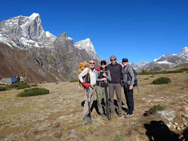 Group of hikers in a mountainous terrain with clear blue skies.