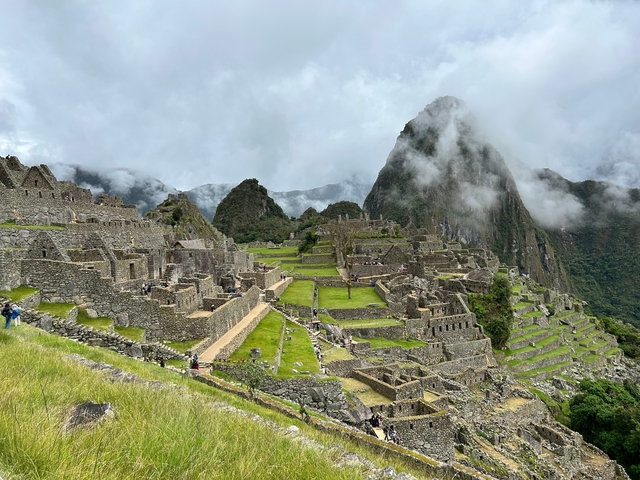 Ancient Inca ruins with lush mountains and clouds enveloping the background.