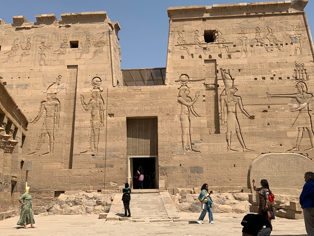 A temple entrance with detailed carvings and visitors.