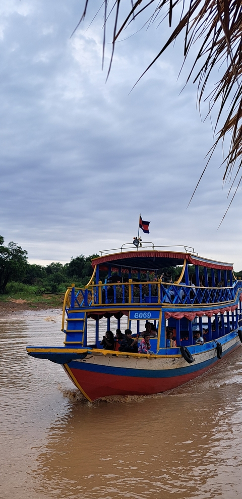 Boat with a National flag on a river in a rural landscape.