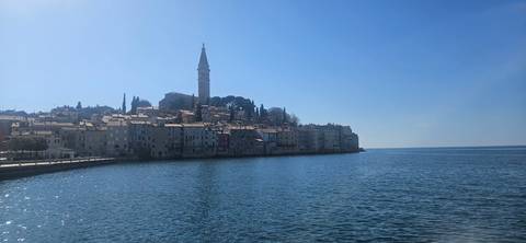A coastal town with medieval architecture against a clear sky.