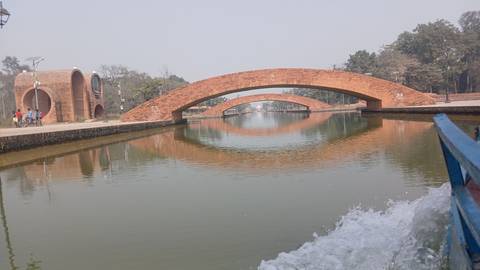 Brick bridges over a calm waterway with scenic surroundings.