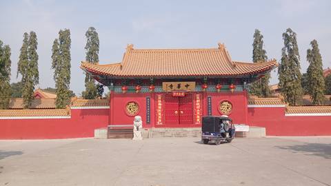 Traditional Chinese architecture with gate and lion statues.