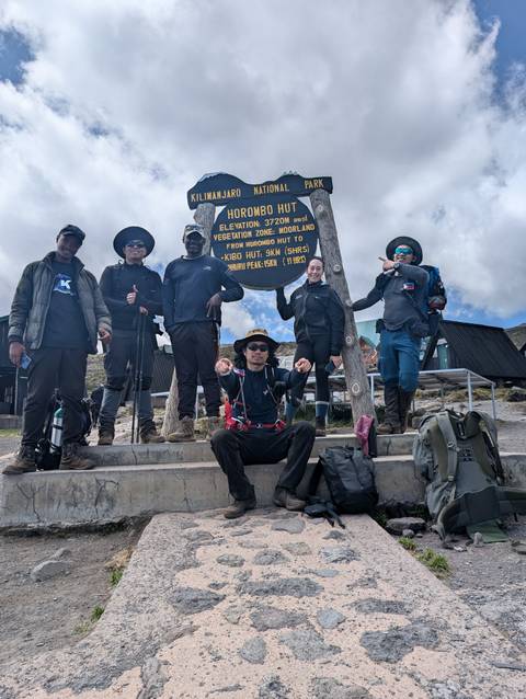 Hiking group posing by a signpost at Horombo Hut.