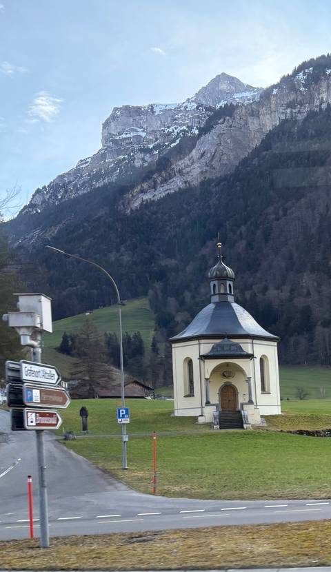 Small chapel with a mountainous background.