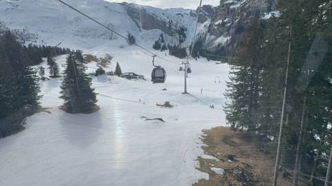 Ski resort area with cable cars and snow-covered slopes.
