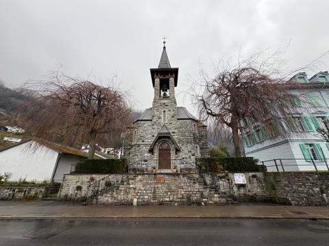 Old stone church with a bell tower on a cloudy day.