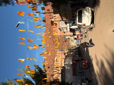 Street festively decorated with orange and yellow flags.