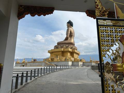 Large Buddha statue overlooking the landscape.