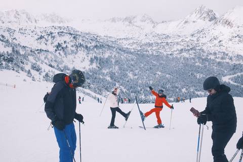 Skiers enjoying a snowy mountain slope with a scenic backdrop.