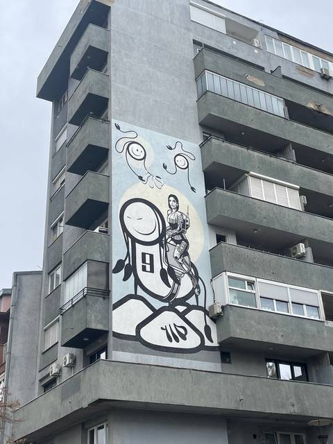 Apartment building with colorful mural on the facade.