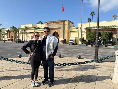 Two people posing in front of a historic building.