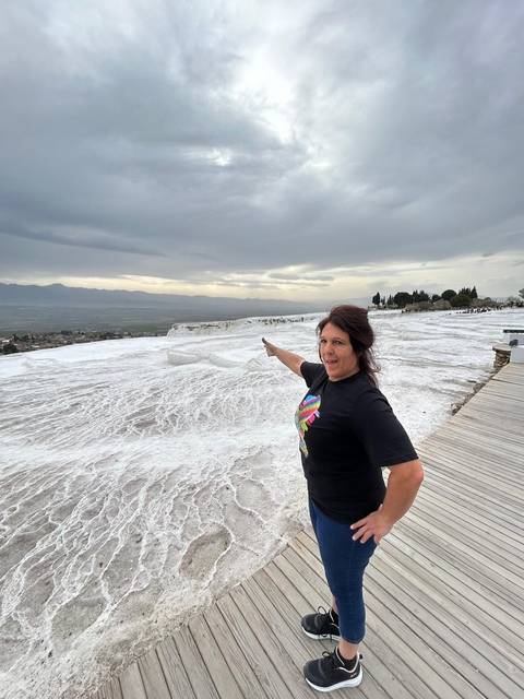 Person posing on the white cliffs of Pamukkale.