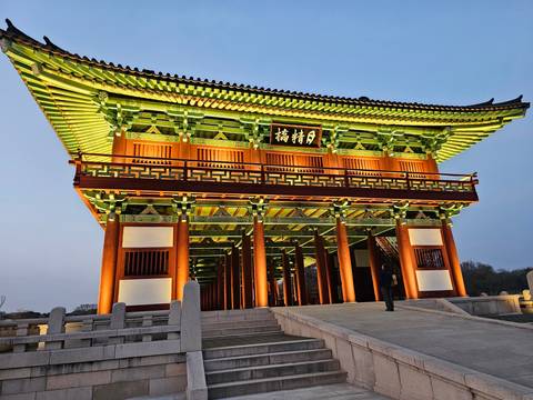 Illuminated traditional Korean gate at dusk.