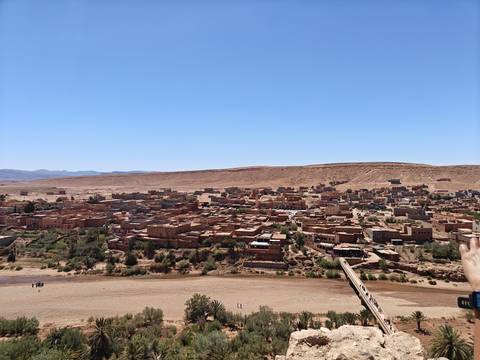 A panoramic view of a town in the desert with a riverbed.