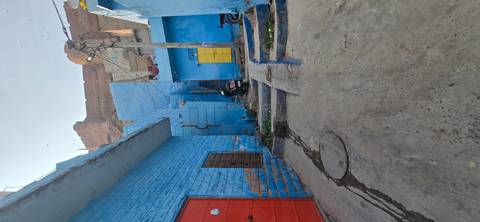 A narrow alleyway with bright blue-painted walls.