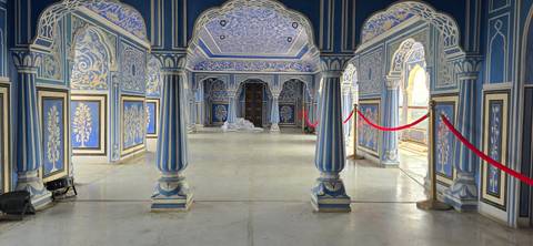 An elaborately decorated blue room with columns and detailed ceiling patterns.