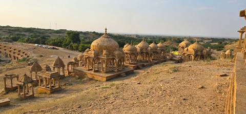 A set of cenotaphs in a desert landscape under a clear sky.