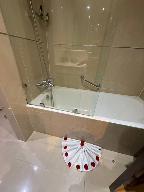 Bathroom with a bathtub and a mounted glass panel.