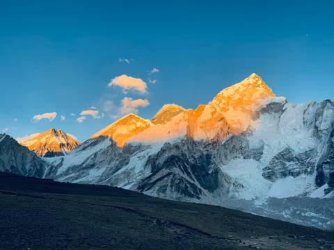 Sunset lighting up a dramatic ice-covered mountain range.