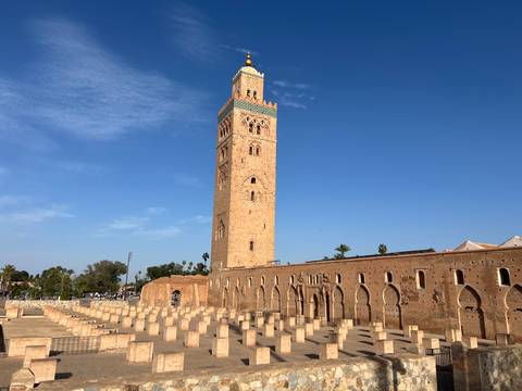A large mosque with a tall minaret and blue sky.