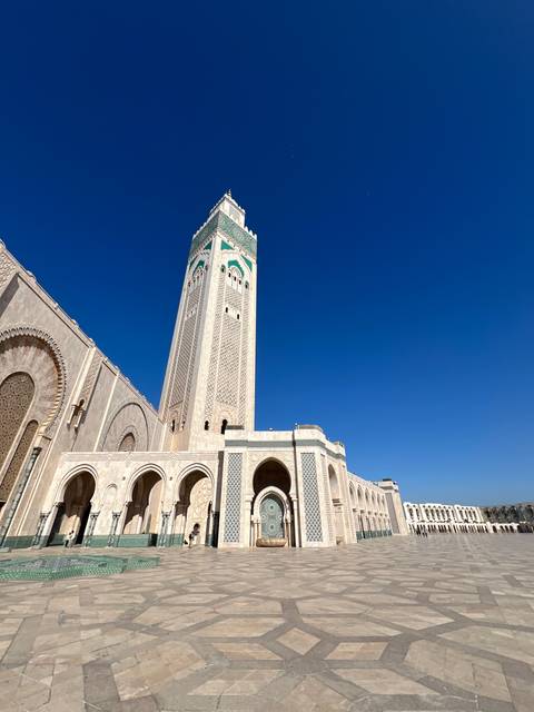 A large mosque with a tall minaret and blue sky.