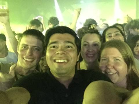 A group of friends smiling in a club-like setting.