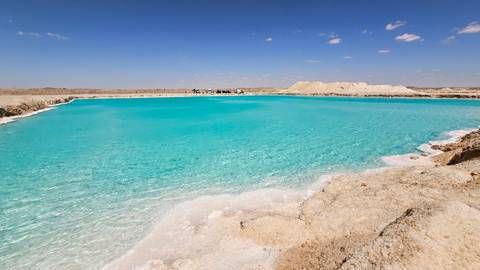 Vibrant blue water in a desert oasis.
