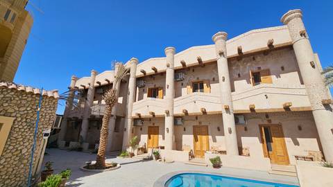 Hotel with traditional architecture under clear blue sky.