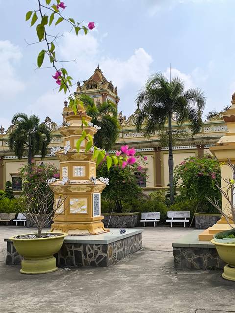 Floral arrangements and yellow structure in a garden setting.