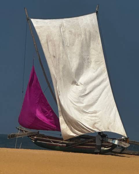 Close-up of colorful boat sails against a blue sky.
