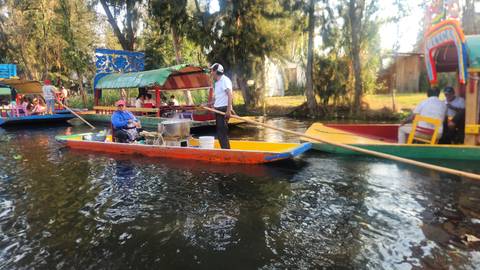 People in colorful boats on a canal.
