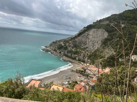 Aerial view of a beach with blue waters and hills.