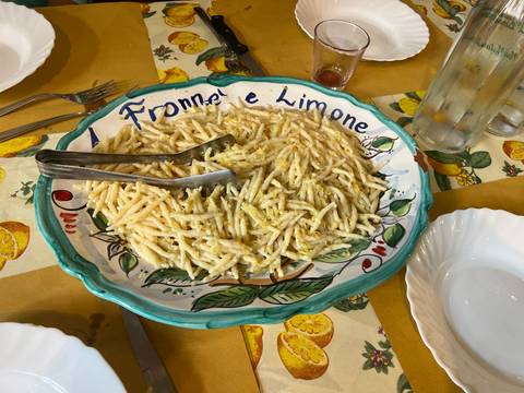 A dish of spaghetti with lemon sauce served on a colorful plate.