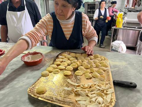 A person preparing ravioli in a kitchen setting.